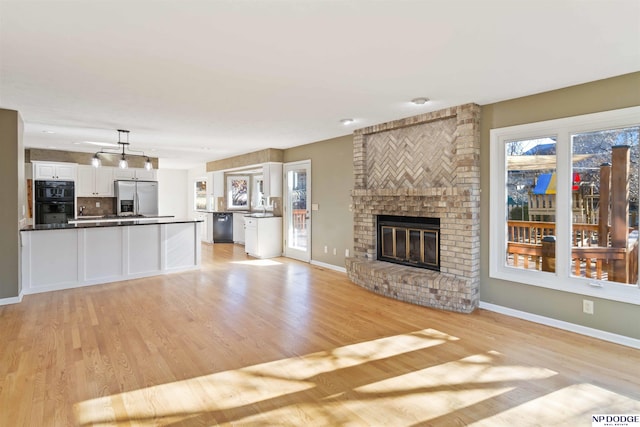 unfurnished living room featuring a fireplace and light hardwood / wood-style flooring