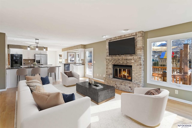 living room with a fireplace and light hardwood / wood-style flooring