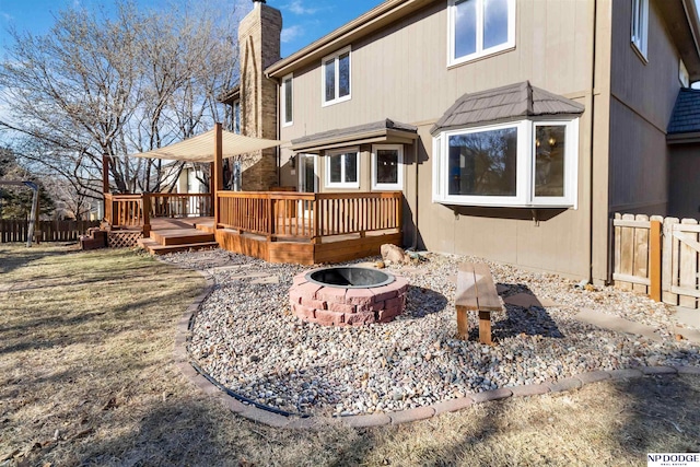 back of house featuring an outdoor fire pit and a deck