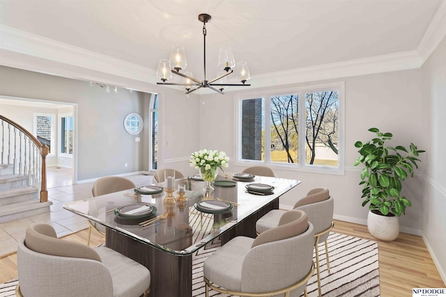 dining space featuring a notable chandelier, light hardwood / wood-style flooring, and crown molding