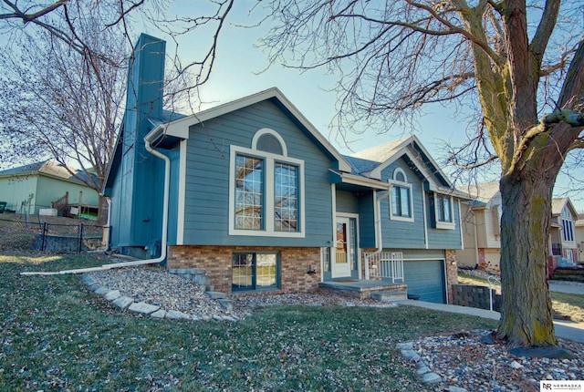 split foyer home featuring a garage and a front lawn