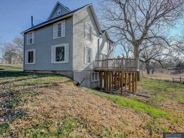 back of property with a yard and a wooden deck