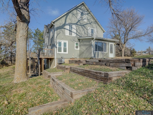 rear view of house featuring a lawn, a deck, and central AC unit