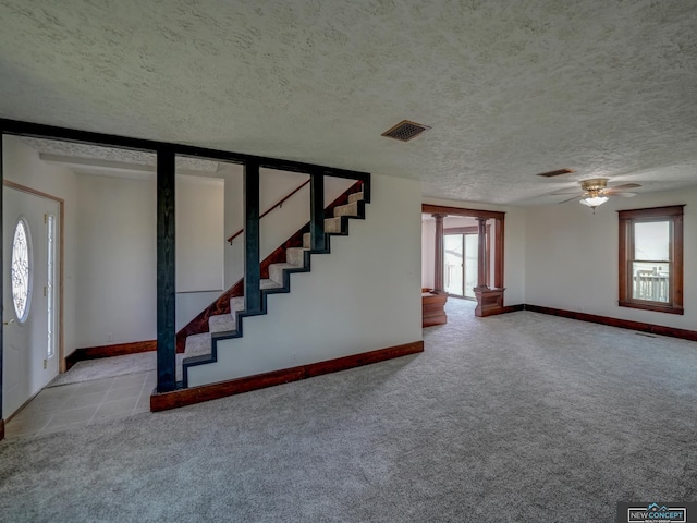 interior space with ceiling fan, light carpet, and a textured ceiling