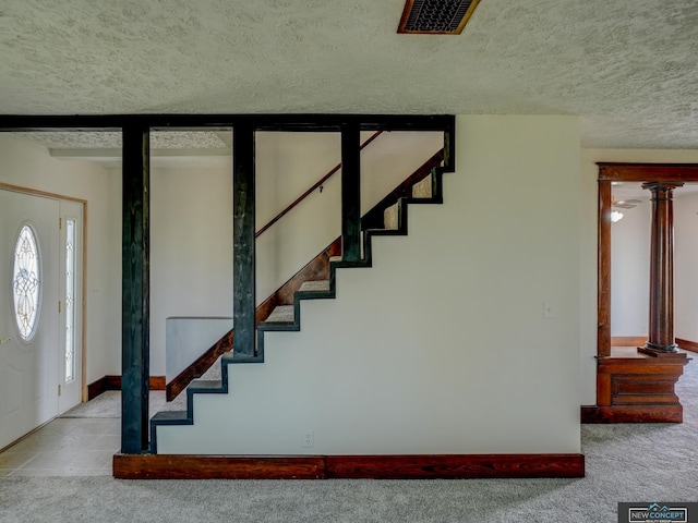 staircase featuring a textured ceiling and carpet