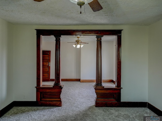 unfurnished living room featuring a textured ceiling, ceiling fan, ornate columns, and carpet