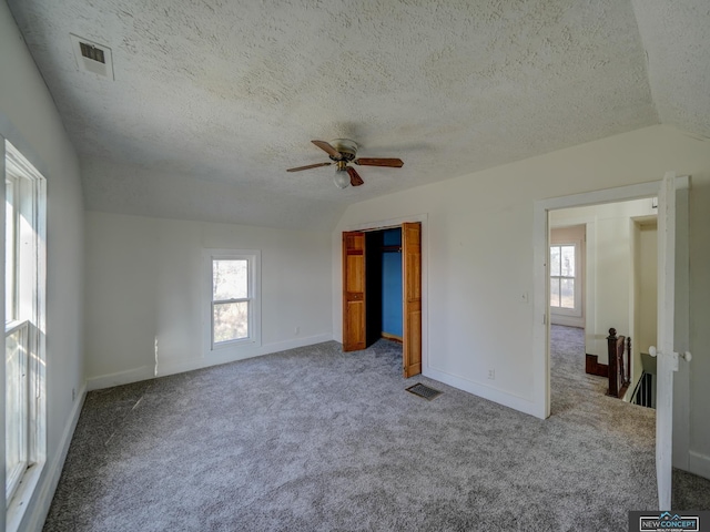 unfurnished room with ceiling fan, lofted ceiling, plenty of natural light, and carpet