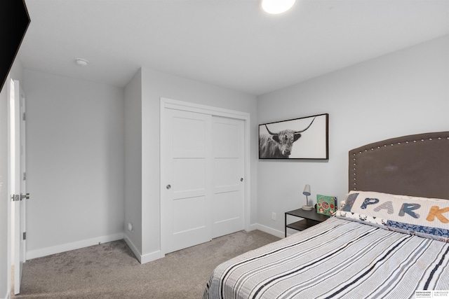 bedroom with a closet and light colored carpet