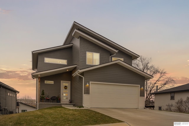 view of front of home with a garage and a lawn