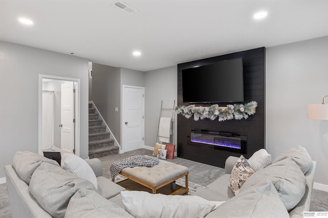 living room with a large fireplace and light colored carpet