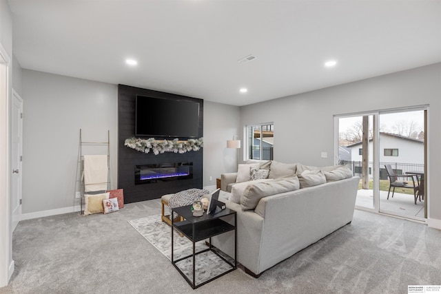 living room with a fireplace, light colored carpet, and a healthy amount of sunlight