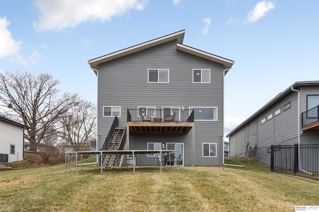 back of house with central AC and a lawn