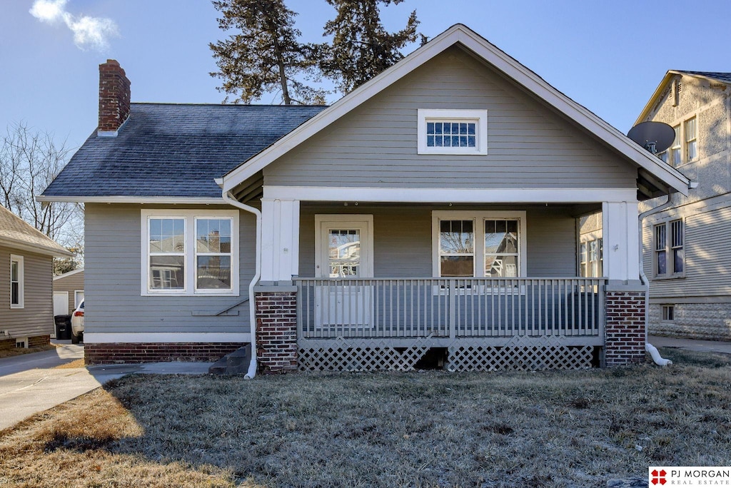 view of front of home with a porch and a front lawn