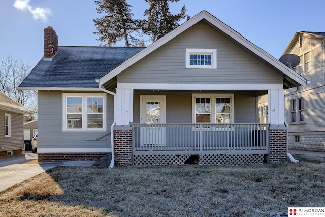 view of front of home with a porch and a front lawn