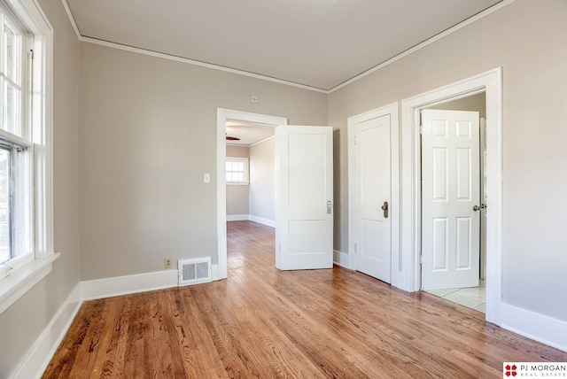 unfurnished bedroom with crown molding and light hardwood / wood-style flooring