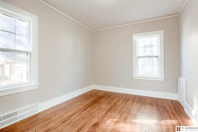 empty room with hardwood / wood-style floors and ornamental molding