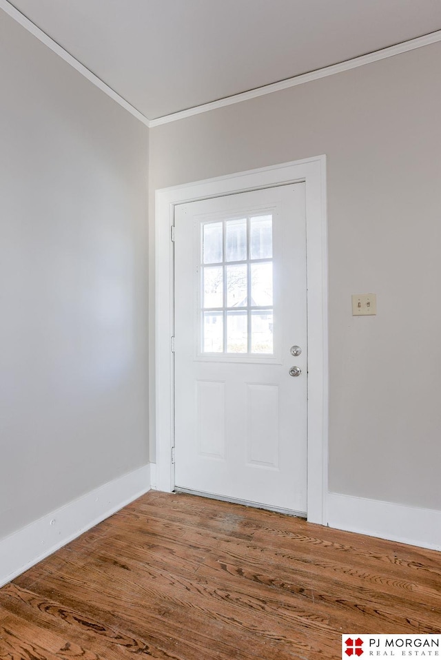 entryway with ornamental molding and wood-type flooring