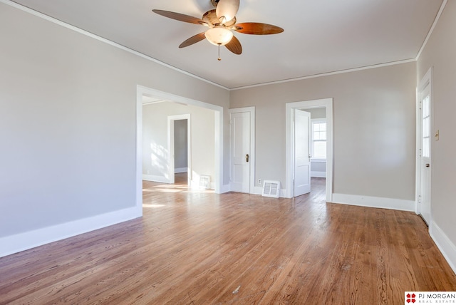 empty room with ceiling fan, hardwood / wood-style floors, and crown molding