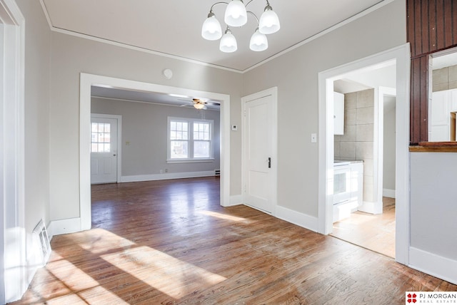 unfurnished dining area featuring ceiling fan with notable chandelier, ornamental molding, and wood-type flooring