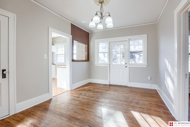 entrance foyer with a chandelier, crown molding, and light hardwood / wood-style flooring