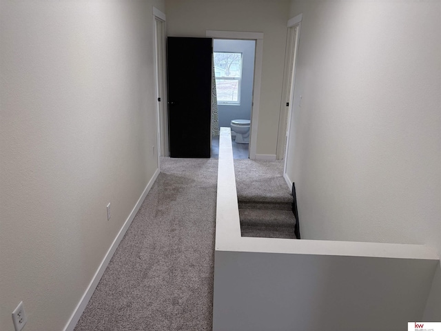 hall with light colored carpet