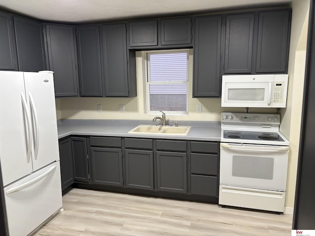 kitchen with white appliances, light hardwood / wood-style floors, and sink