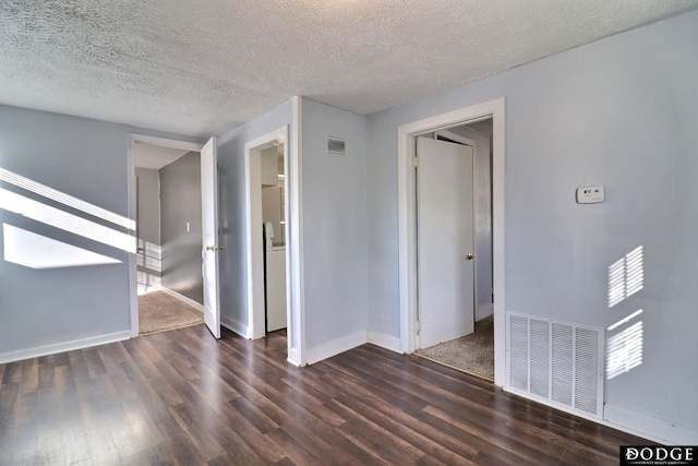 unfurnished room featuring a textured ceiling and dark hardwood / wood-style flooring