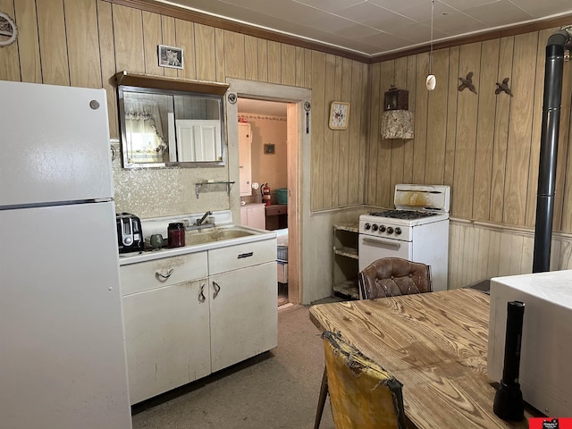 kitchen featuring white appliances, ornamental molding, and wood walls