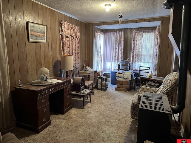 carpeted office with a textured ceiling and wooden walls