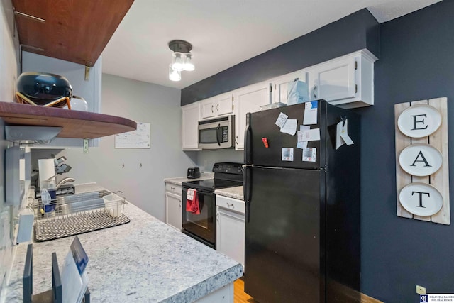 kitchen featuring white cabinets and black appliances