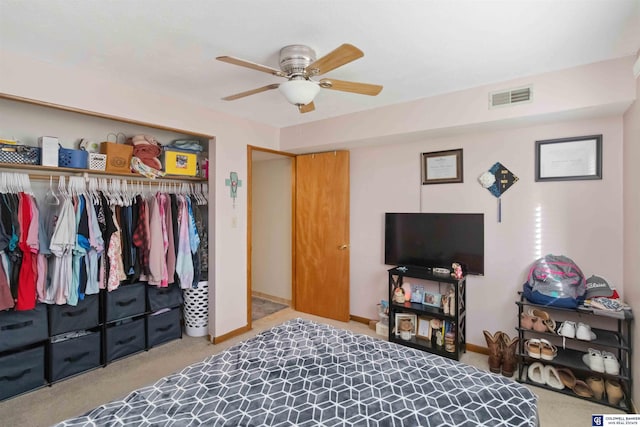 carpeted bedroom featuring ceiling fan and a closet