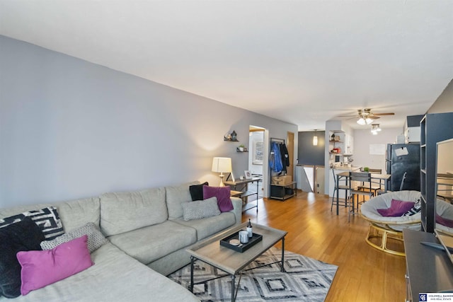 living room with ceiling fan and hardwood / wood-style flooring