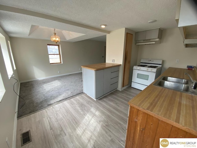 kitchen featuring pendant lighting, sink, an inviting chandelier, white gas range, and light wood-type flooring