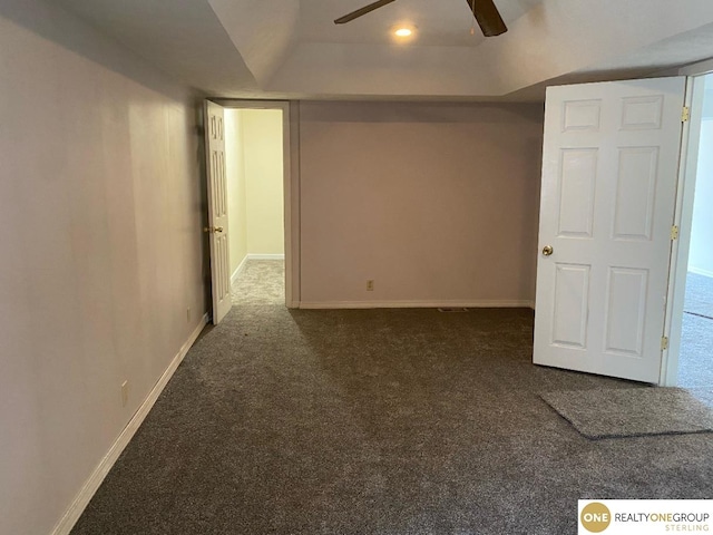 basement with dark colored carpet and ceiling fan