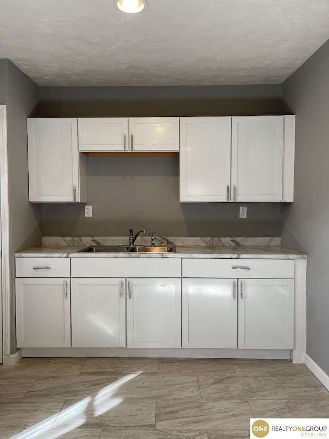 kitchen with white cabinetry and sink