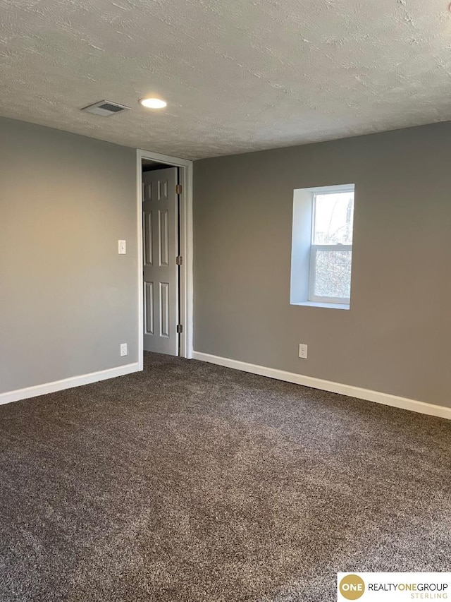 carpeted spare room with a textured ceiling