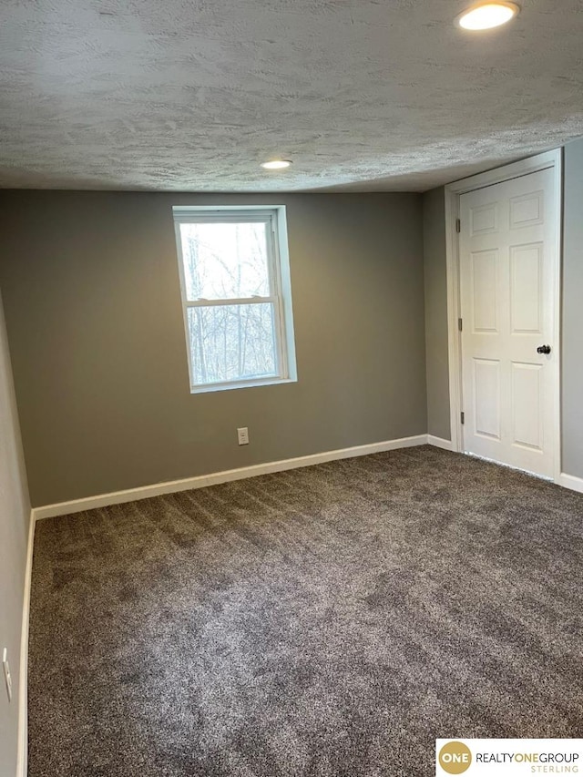 unfurnished room with carpet and a textured ceiling