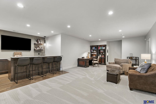 living room featuring bar area and light hardwood / wood-style flooring