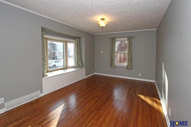 spare room with a textured ceiling, ornamental molding, and dark hardwood / wood-style floors