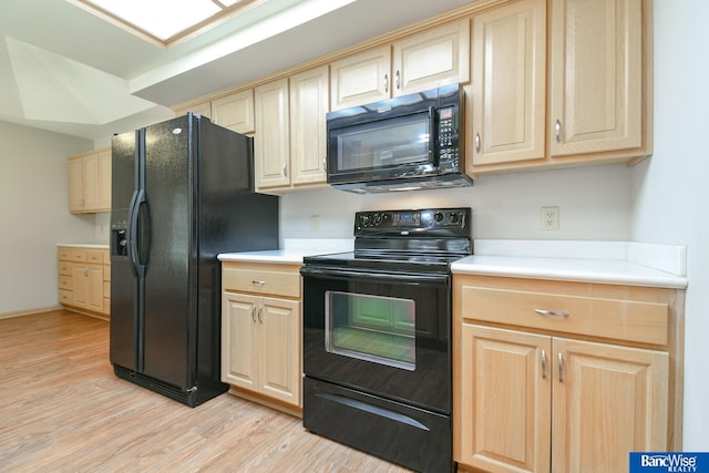 kitchen featuring black appliances and light hardwood / wood-style flooring