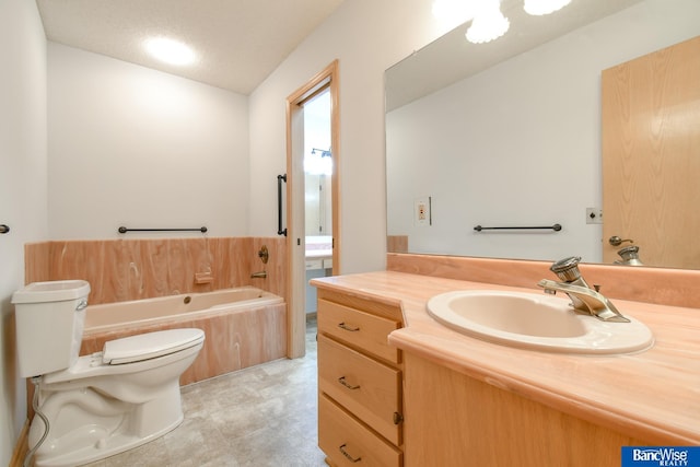 bathroom featuring a textured ceiling, a relaxing tiled tub, vanity, and toilet