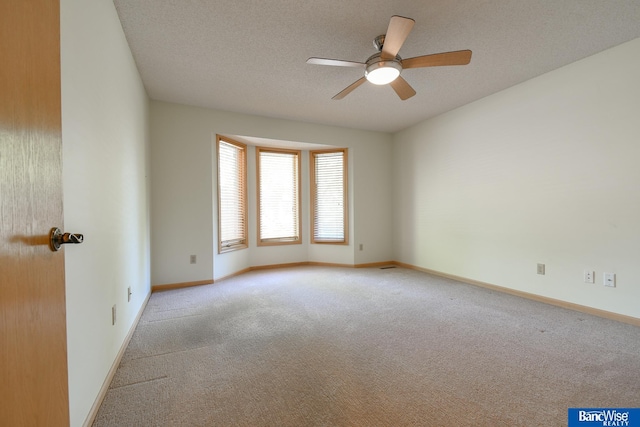 carpeted spare room with a textured ceiling and ceiling fan