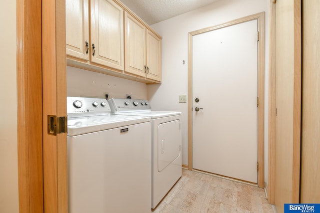 laundry area featuring a textured ceiling, cabinets, and separate washer and dryer