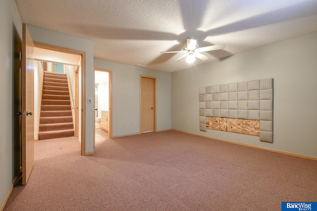 interior space with a textured ceiling, ceiling fan, and light colored carpet