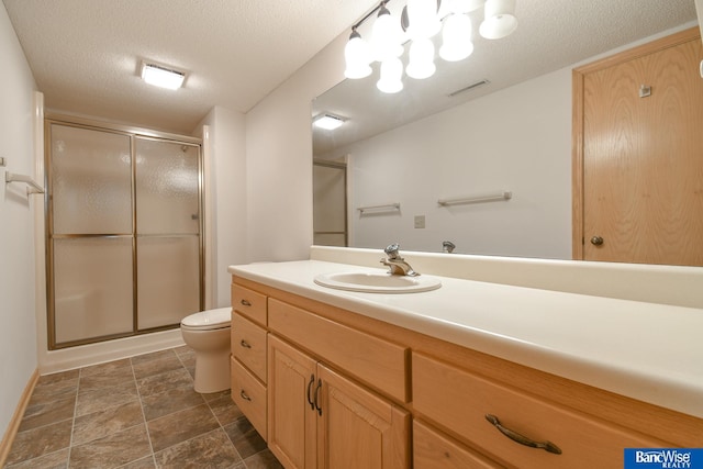 bathroom with toilet, an enclosed shower, a textured ceiling, and vanity