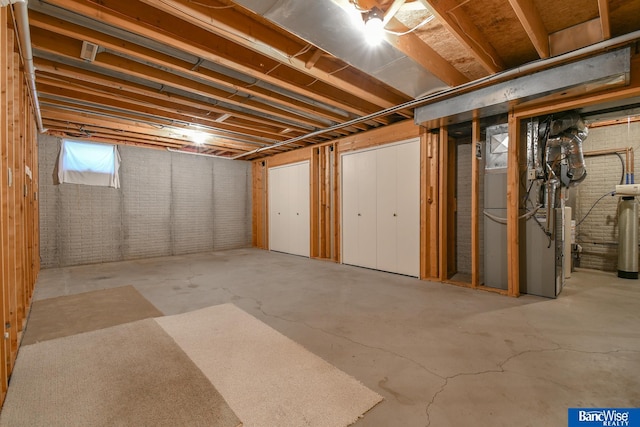 basement with heating unit and brick wall