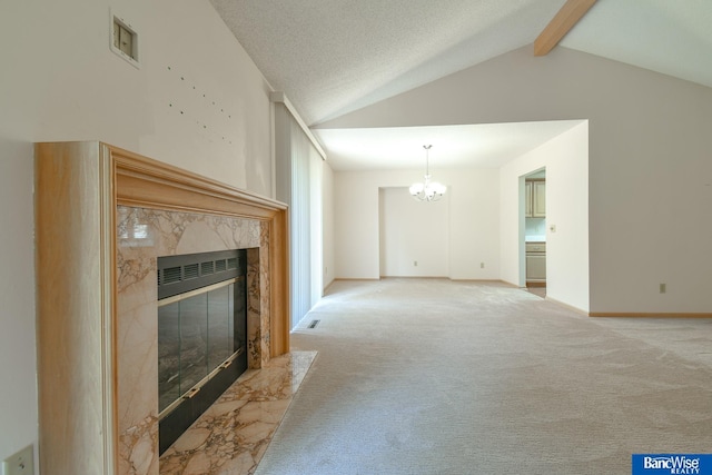 carpeted living room with a high end fireplace, a chandelier, lofted ceiling with beams, and a textured ceiling