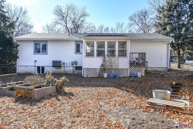 rear view of house with central AC unit and a sunroom