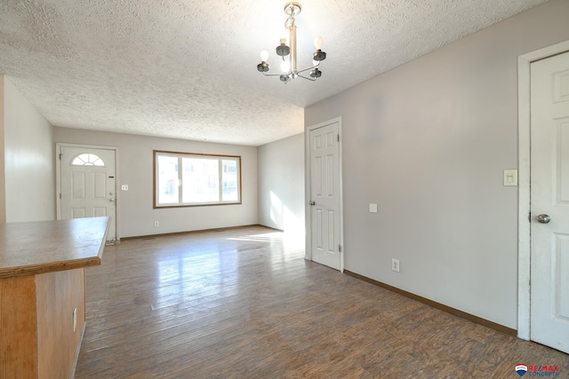 interior space featuring a textured ceiling, a chandelier, and dark wood-type flooring