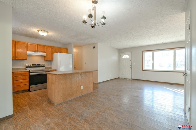 kitchen with electric stove, a center island, decorative light fixtures, an inviting chandelier, and white refrigerator